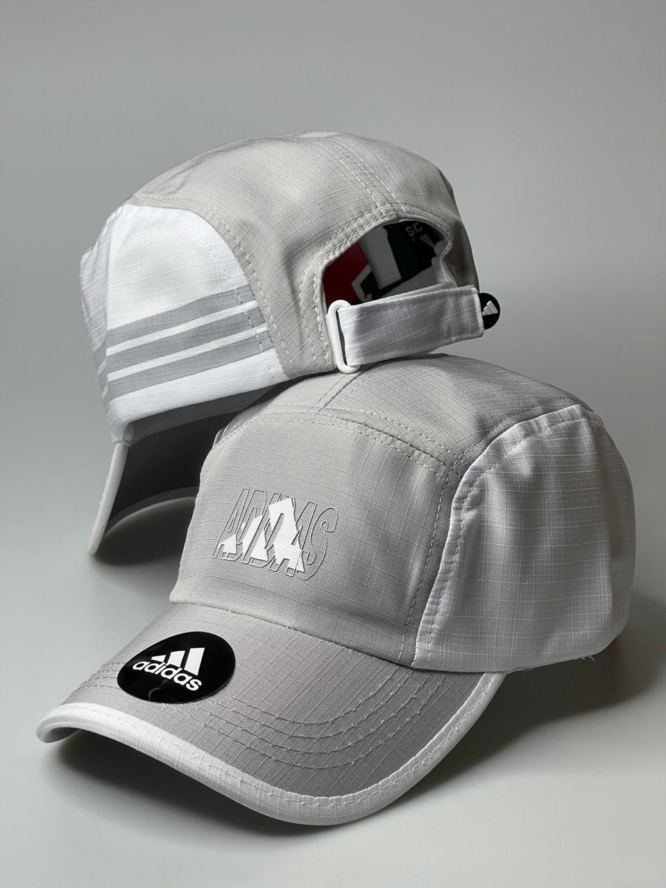 Boné Adidas cinza claro com logo na frente e detalhe de listras, fundo neutro