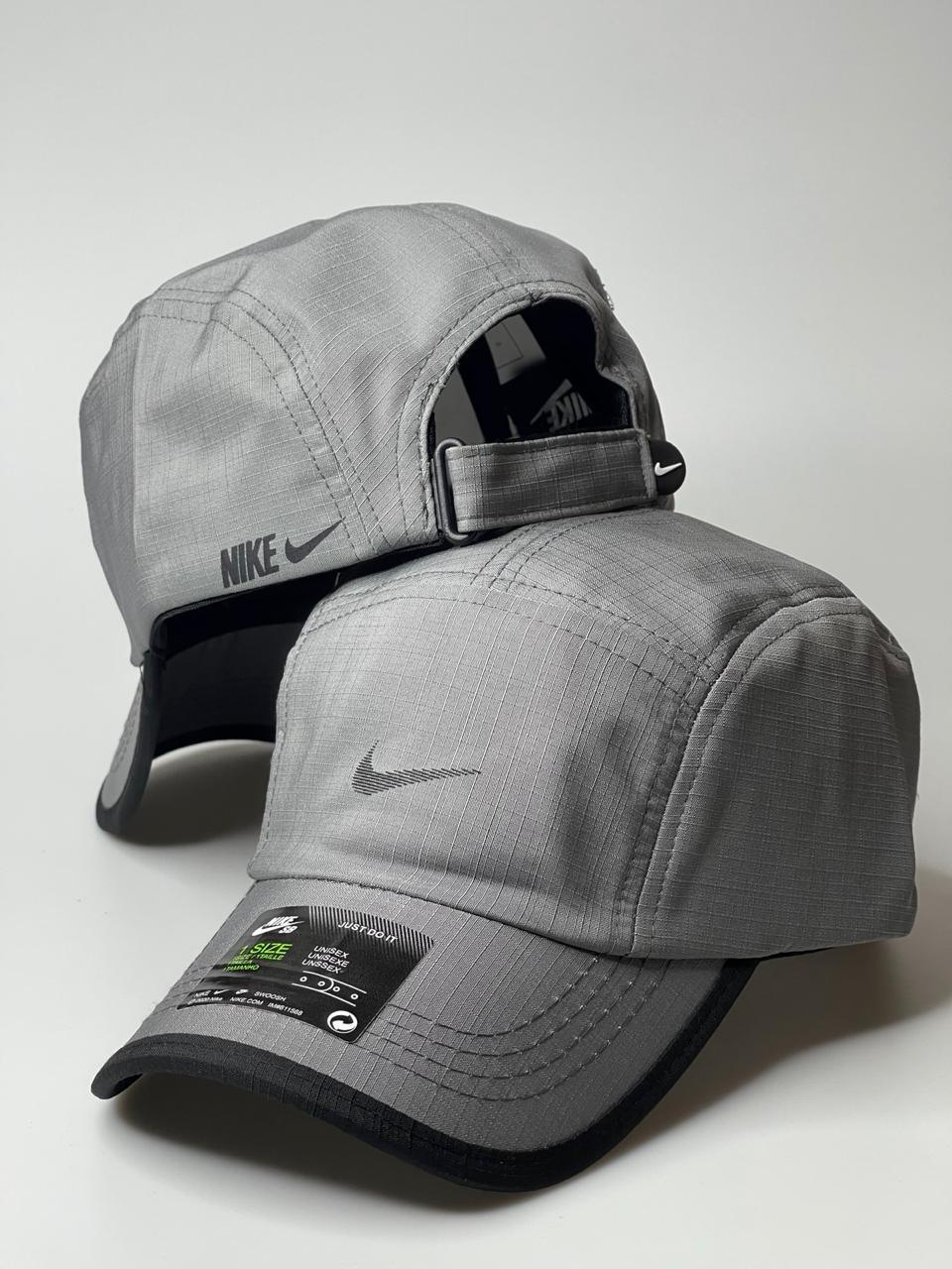 Boné Nike cinza claro unissex, aba curva, logo bordado, fundo branco.