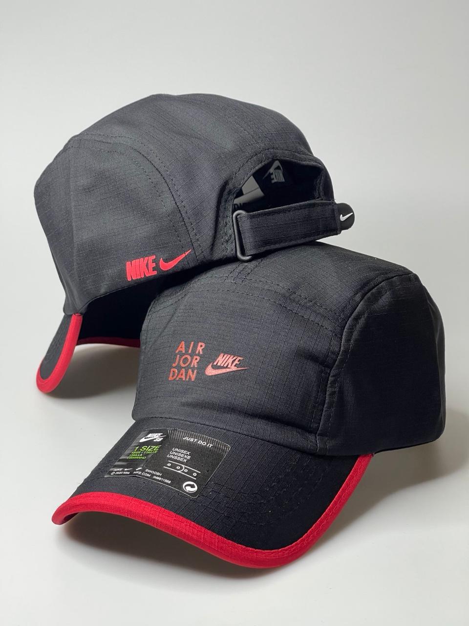 Boné Nike Air Jordan preto com detalhes vermelhos, logos bordados, fundo branco.