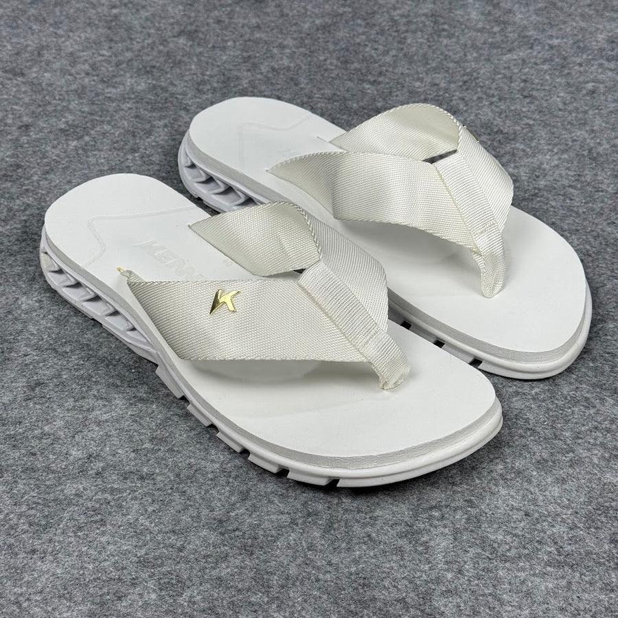 Sandália Kenner Rakka branca com tiras largas, detalhe dourado, sobre fundo cinza.