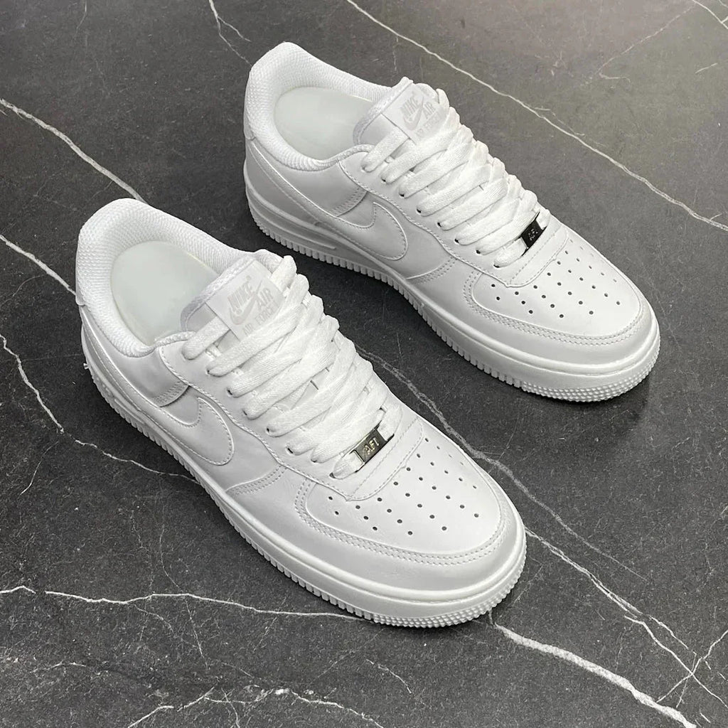 Tênis Nike Air Force 1 branco em couro sobre piso preto marmorizado
