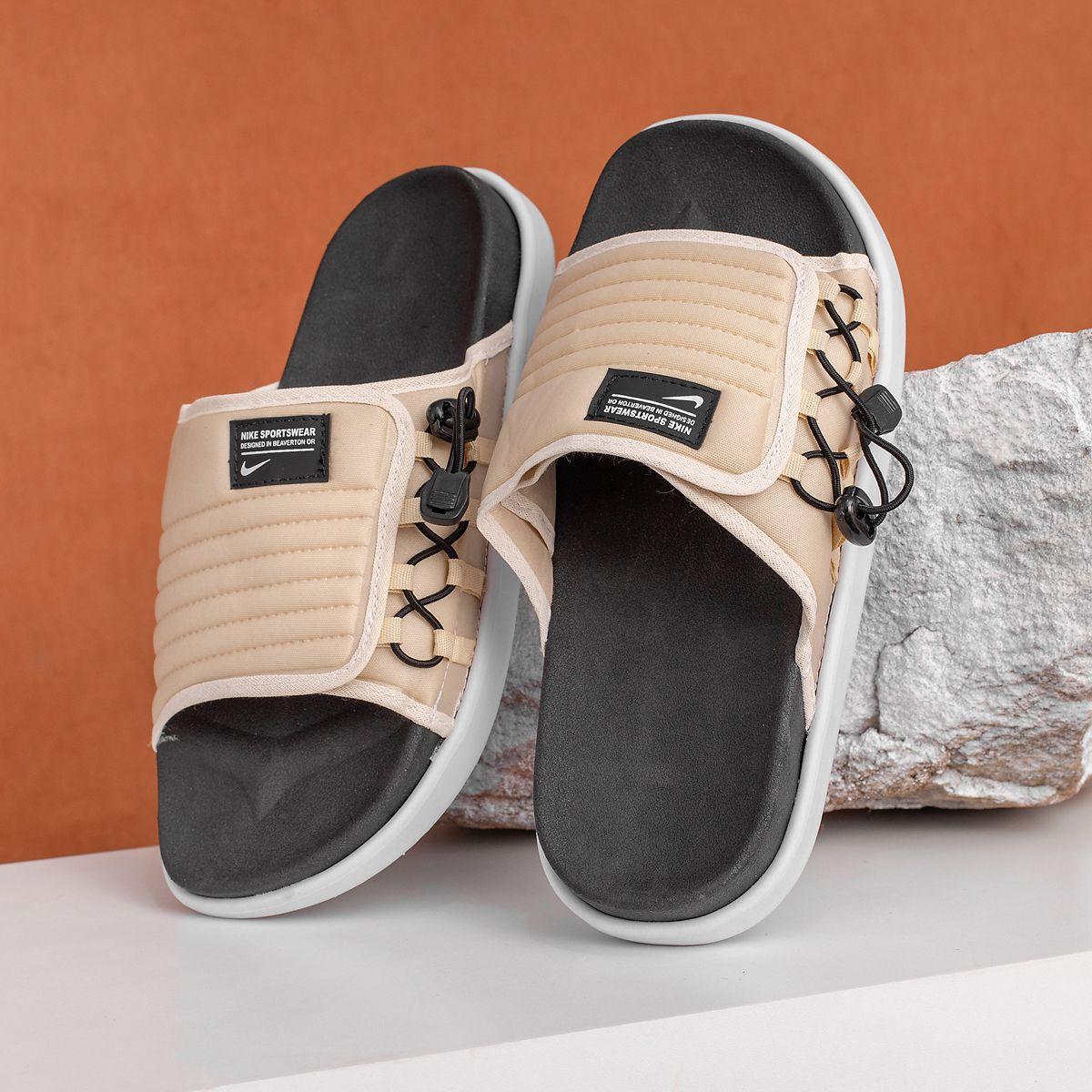 Chinelo Nike Asuna 2 bege com detalhe preto, sola branca, sobre fundo laranja